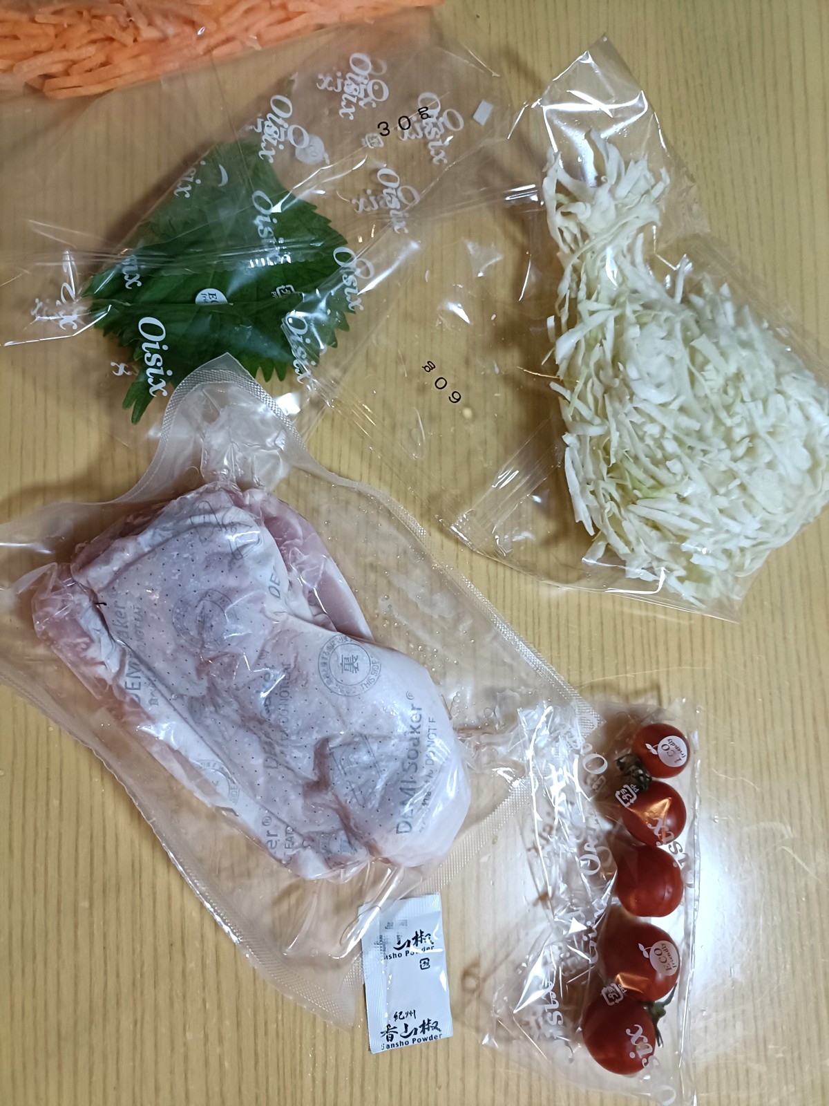 個包装の豚肉、トマト、大葉、人参、キャベツと山椒の袋