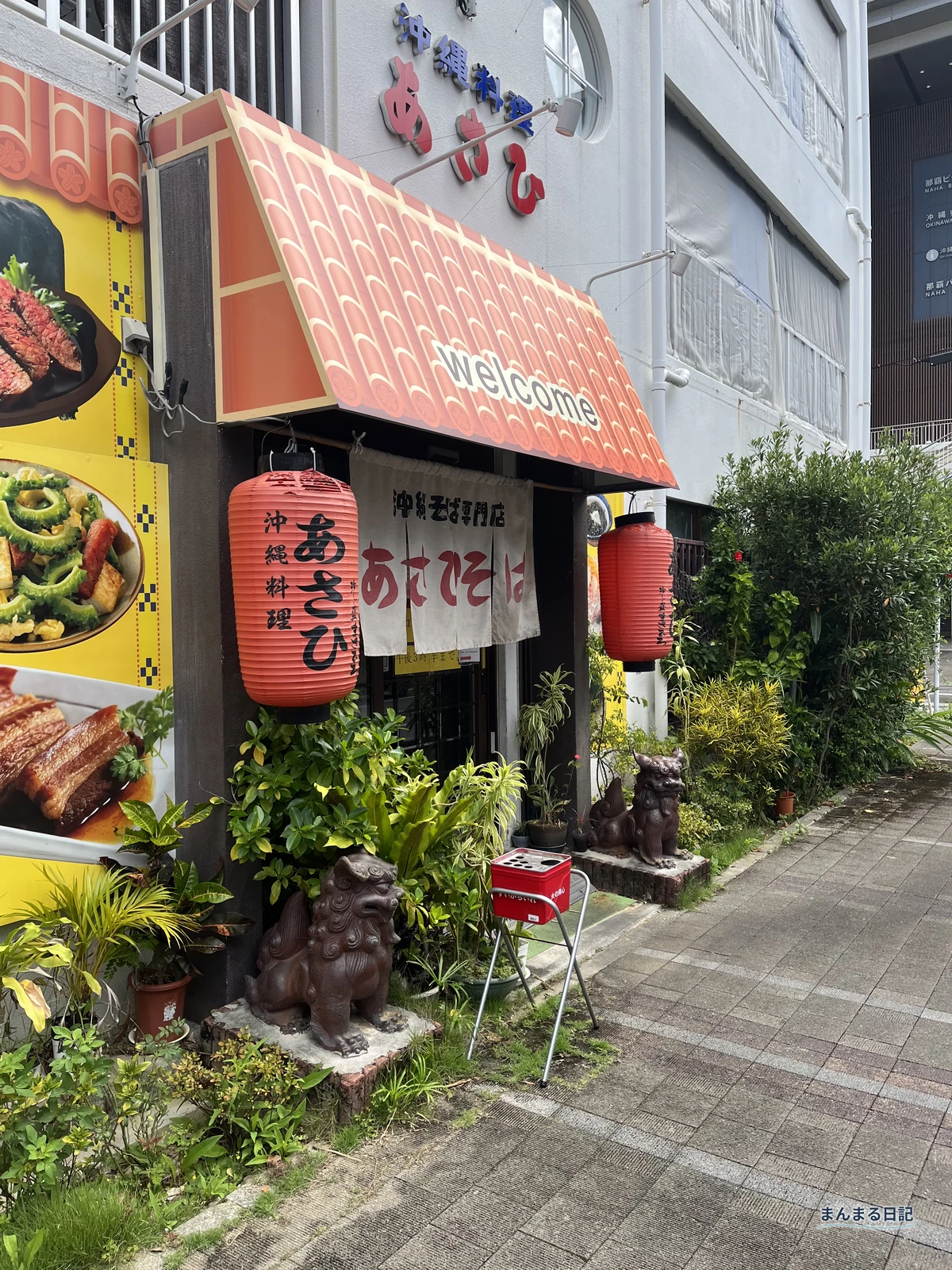 沖縄料理あさひの看板とシーサーが並ぶ店頭